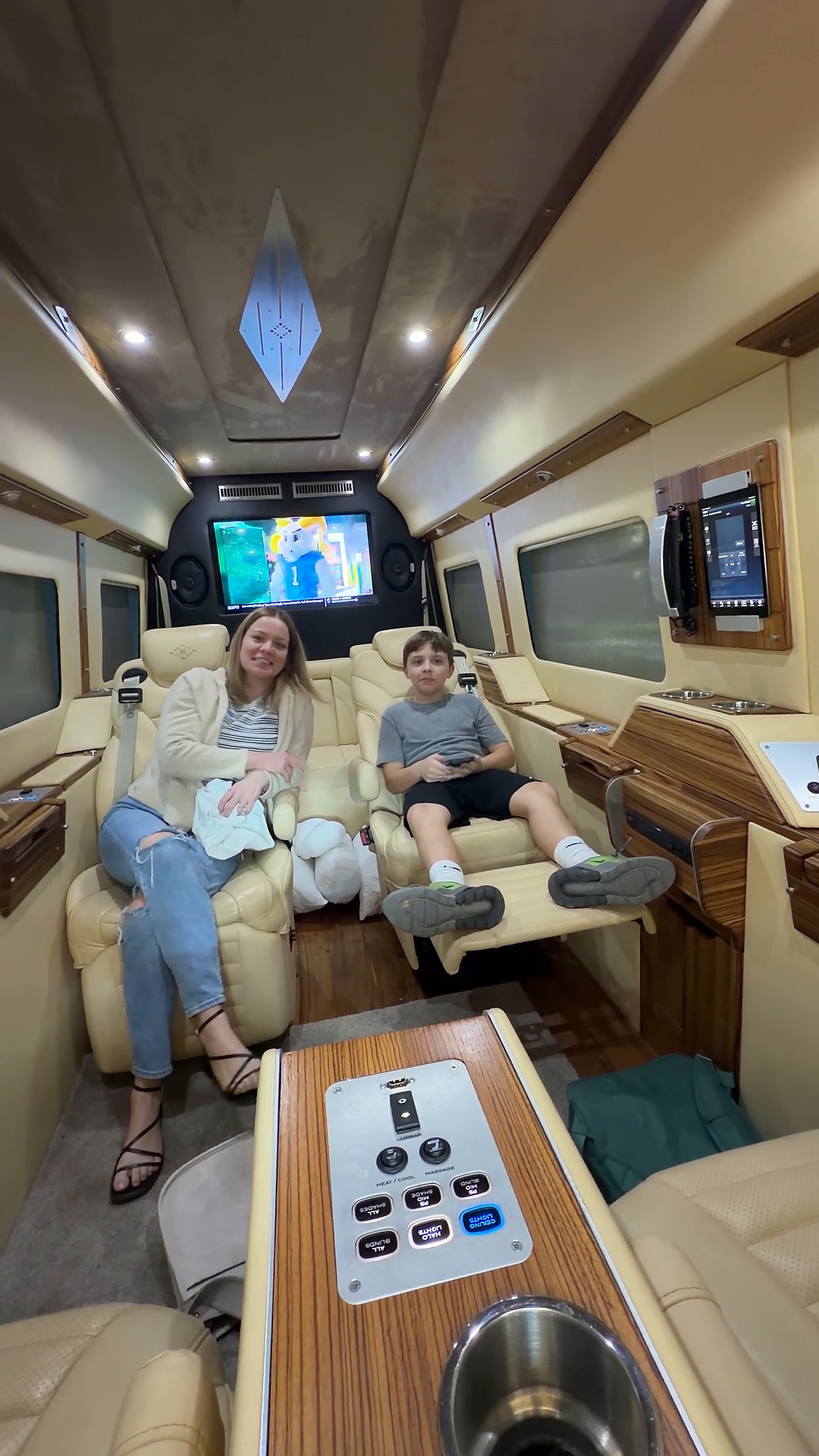 Passengers relaxing on the rear seats with the TV on